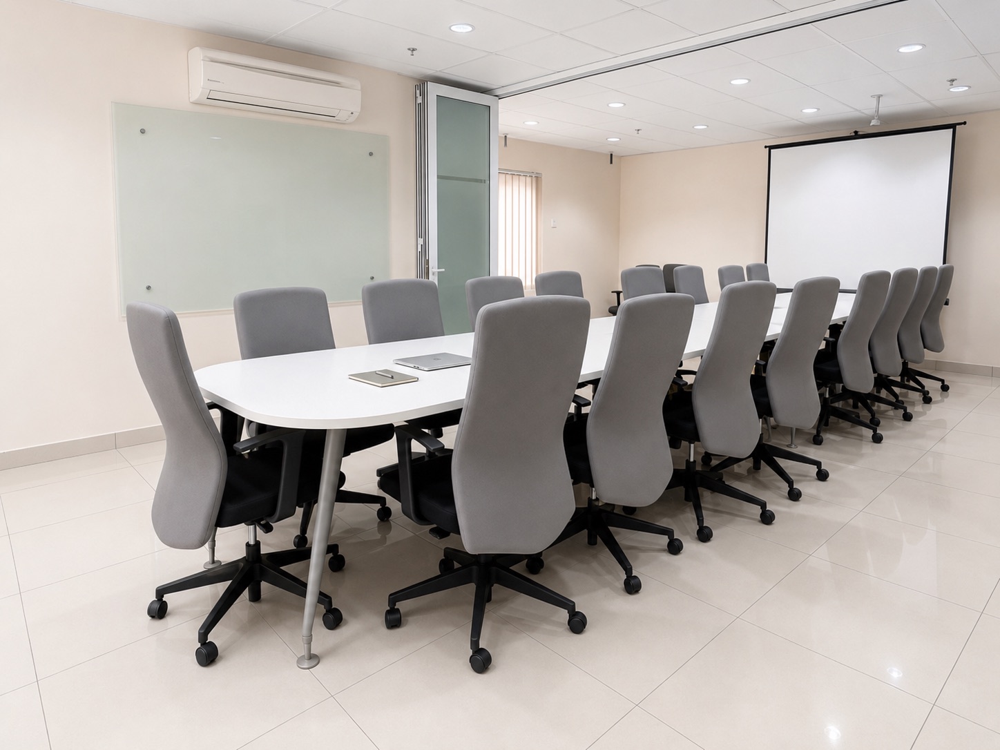 Au Courant Meeting Room with a long table, screen and glass board